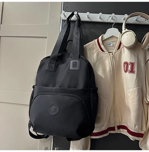 Detail eines schwarzen wasserdichten Nylonrucksacks mit Logo und Reißverschlusstasche