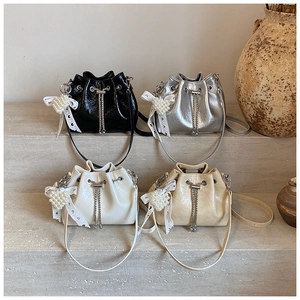 Detail view of colorful drawstring bucket bags with chain straps and pearl bow charms