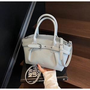 Detailed view of light blue lychee texture leather tote with decorative buckle and strap