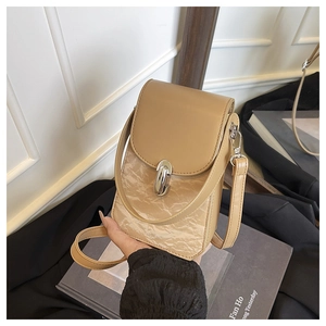 Détail d'un sac bandoulière kaki avec fermoir en métal argenté et texture plissée