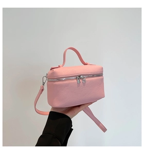 Detail of pink lychee texture mini crossbody bag with silver lock and top handle