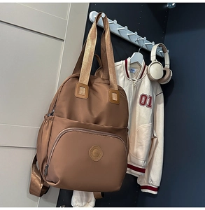 Brauner wasserabweisender Nylon Rucksack an einem Haken mit großen Staufächern