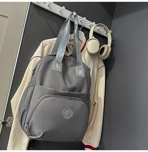 Nahaufnahme eines dunkelgrauen Nylon-Rucksacks mit praktischen Fächern und Rundlogo