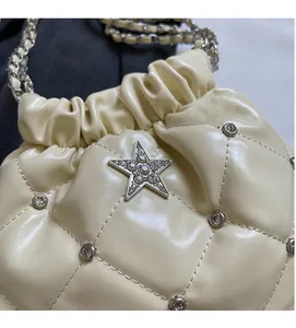 Détail du sac seau matelassé crème avec étoile en strass et chaîne argentée