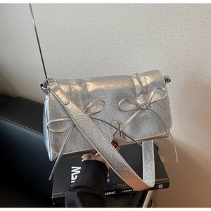 Détail du sac bandoulière argenté métallisé plissé avec deux nœuds et large sangle