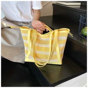 Detailed view of yellow striped mesh tote bag featuring smooth PU leather handle and drawstring