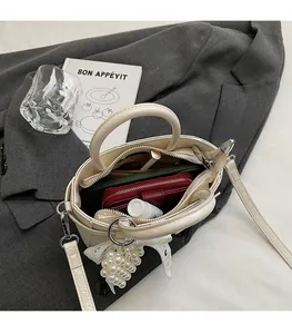 Detail view of the spacious inner compartment of the creamy white soft leather bucket bag