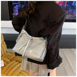 Detail einer funkelnden hellblauen Strass-Jeanshandtasche, die über der Schulter getragen wird