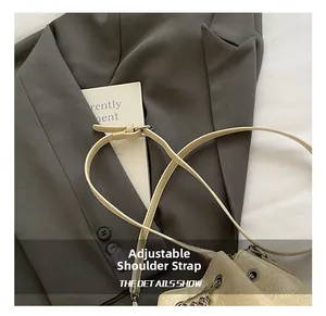 Details des verstellbaren Riemens und der Knitteroptik an der beigen Beuteltasche