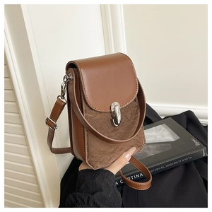 Détail d'un sac bandoulière en cuir marron avec fermoir pivotant argenté et fine lanière