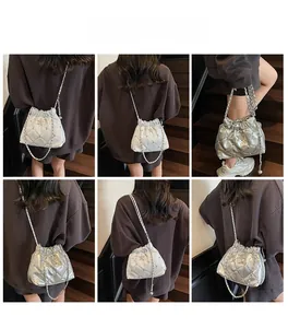 Vues détaillées du sac seau argenté matelassé avec logo étoile et bandoulière chaîne