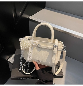 Détail du sac seau plissé blanc crème avec pendentif perle coeur et nœud en dentelle
