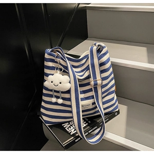 Detail of blue and white striped canvas tote bag with cute plush cloud pendant