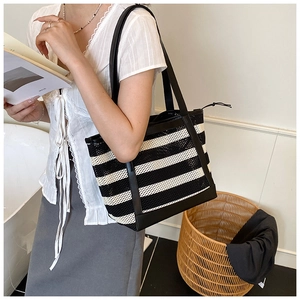 Detailed view of the large striped tote bag being worn as a casual shoulder bag