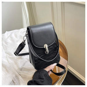 Détail du sac bandoulière noir en similicuir avec texture plissée et boucle argentée