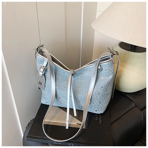 Detaillierte Nahaufnahme der glitzernden Strassoberfläche und des Leder-M-Logo-Anhängers der Tasche