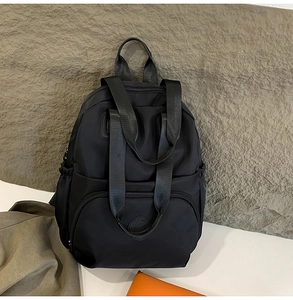 Detail des schwarzen Nylon-Rucksacks mit verstärkten Griffen und großer Fronttasche