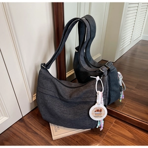 Detailed mirror shot of a dark grey hobo bag with a cute Capybara charm accessory