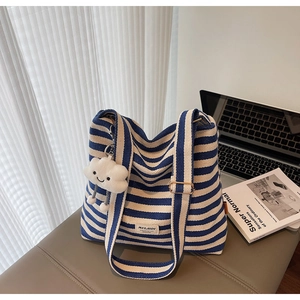 Blue and white striped canvas tote bag with a white plush cloud charm and wide strap