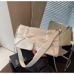 Détail du sac baguette blanc en cuir froissé avec deux nœuds décoratifs à l'avant