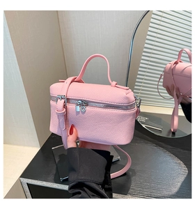 Detail of pink lychee leather vanity bag showing top handle and mirror reflection
