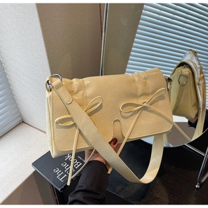 Détail d'un sac à nœud jaune crème en cuir PU froissé montrant la texture et le design