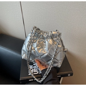 Détail d'un sac seau matelassé argenté avec étoile en diamant et bandoulière en chaîne