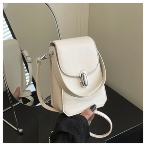 Détail d'un petit sac bandoulière blanc crème avec un fermoir rotatif ovale en métal argenté