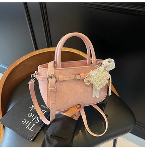 Détail du mini sac seau rose en cuir verni avec breloque cœur en perles et dentelle