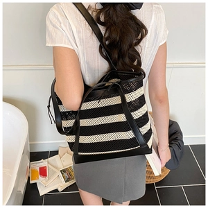 Detail of black and white striped mesh tote bag with smooth leather shoulder straps