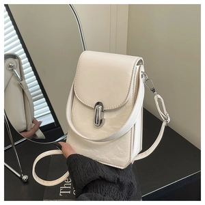 Détail du mini sac carré crème avec fermoir en U argenté et texture en cuir plissé