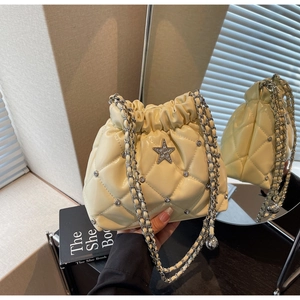 Détail du sac seau matelassé crème avec strass et ornement d'étoile en argent