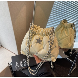 Détail du sac seau matelassé jaune clair avec étoile en strass et chaîne argentée