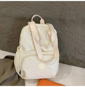 Detailansicht eines beigen Nylon-Rucksacks mit wasserfestem Stoff und Seitentaschen