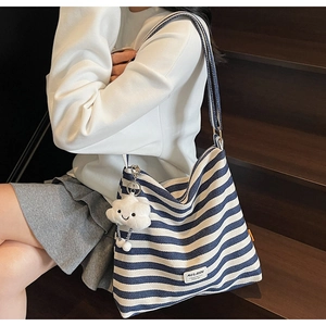 Detailed close-up of large blue and white striped canvas tote bag with cloud charm accessory