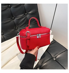 Close-up of red litchi grain leather handbag with silver zippers and hand-held details