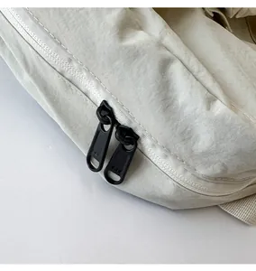 Detailed shot of smooth dual black zippers on a beige drawstring backpack fabric