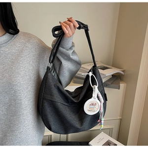 Close-up of gray denim hobo bag with adjustable strap and cute Capybara charm