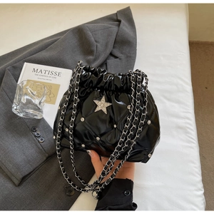 Détail du sac seau en cuir noir matelassé avec étoile strass et chaîne argentée