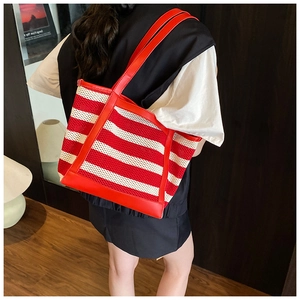 Detail of red and cream striped hollow knit tote bag with leather straps and large capacity