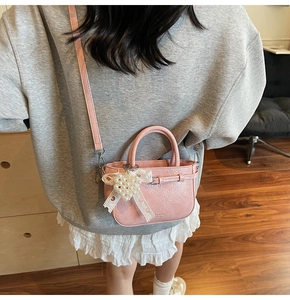 Détail du mini sac seau en similicuir rose avec breloque cœur en dentelle perlée et sangle