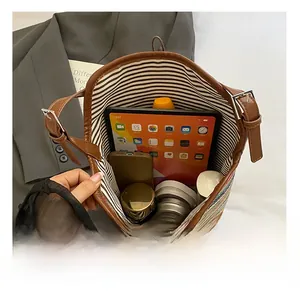 Top view of the spacious bucket bag interior with striped lining and brown leather strap