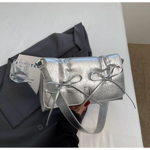 Détail du sac bandoulière argenté métallisé avec texture plissée et nœuds élégants