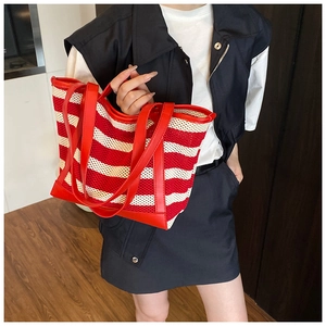 Detailed close-up of red and beige striped tote bag with woven mesh texture and glossy handles
