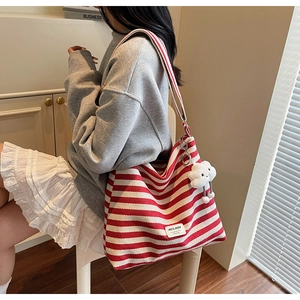 Detail of red striped canvas tote bag with cloud charm and woven Muladi brand tag