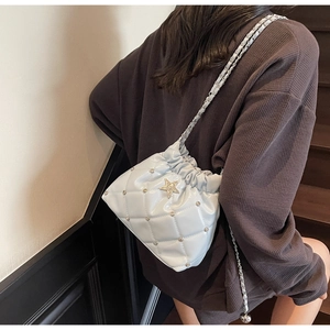 Détail du sac seau matelassé bleu clair avec rivet étoile argenté et chaîne
