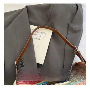 Detail of multi-color zigzag straw bucket bag with leather strap and horn toggle closure