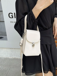 Petit sac bandoulière blanc cassé avec fermoir ovale argenté porté par un mannequin