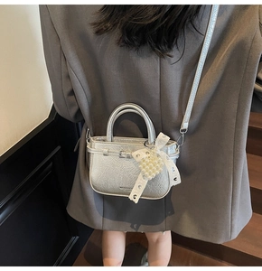 Détail du sac en cuir plissé argenté avec nœud en perles et bandoulière réglable
