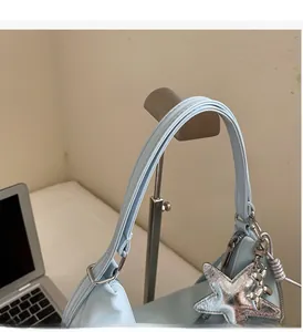 Detailed view of light blue tote handle with silver star and balloon dog pendant decor